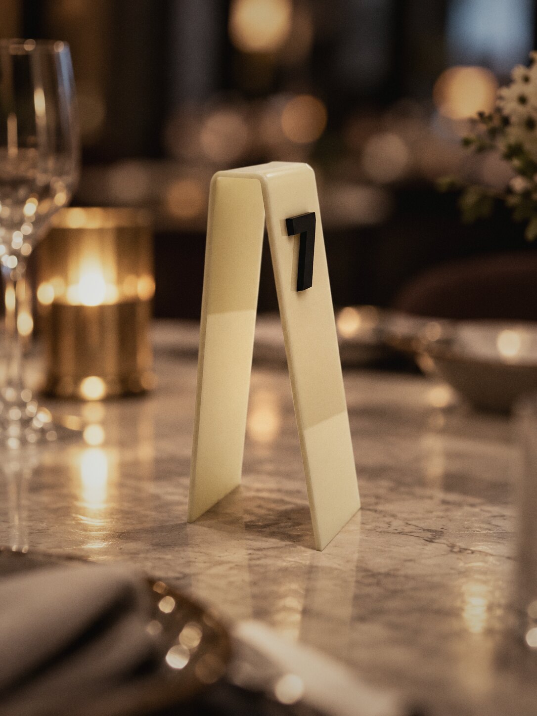 Cream acrylic table number 7 on a restaurant table