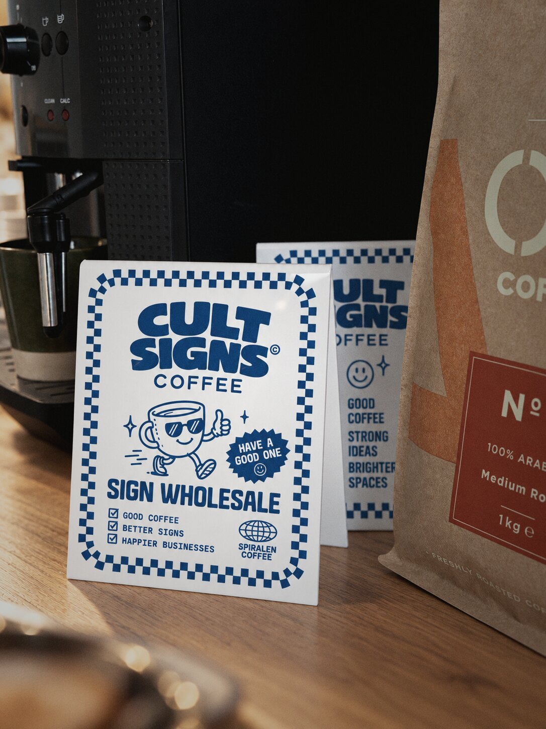 Printed acrylic counter sign on a cafe counter next to a coffee machine